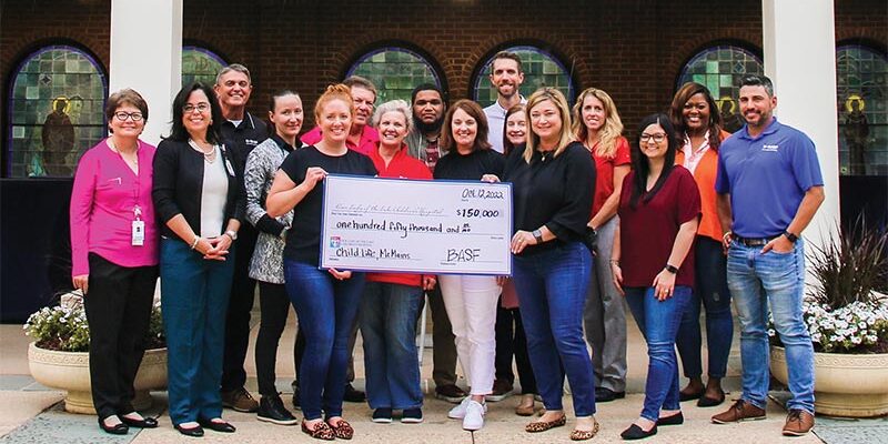 outdoor group photo holding giant check