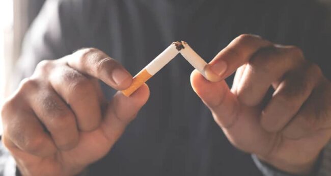 hands breaking cigarette in half