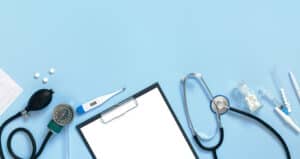 clipboard and medical instruments on light blue background