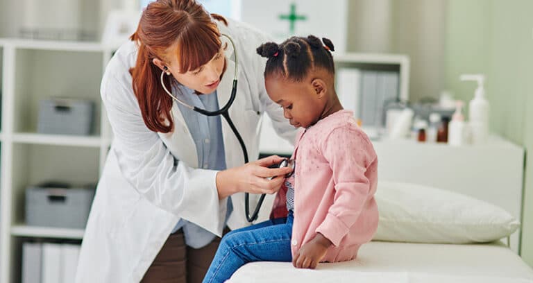 pediatrician listening to child's heart with stethoscope
