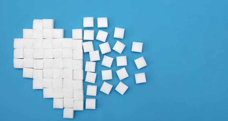 sugar cubes in shape of heart on blue background