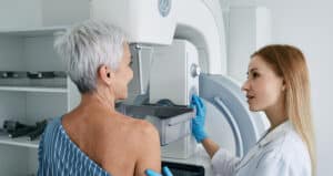 woman having mammogram and tech helping her