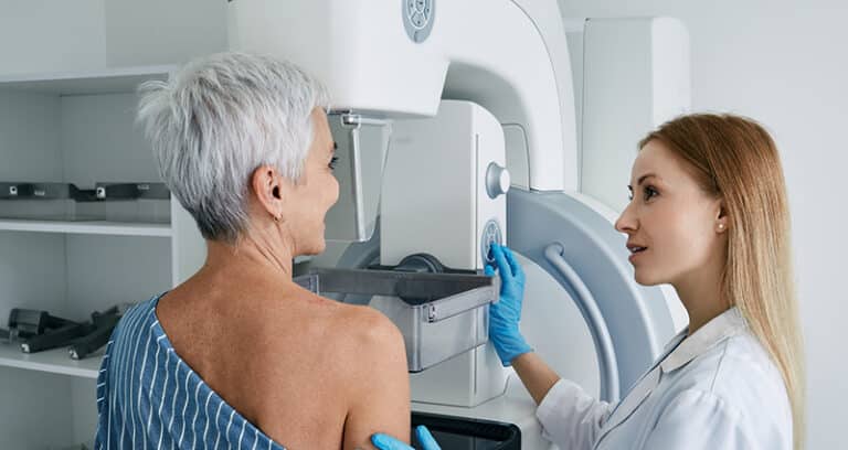 woman having mammogram and tech helping her