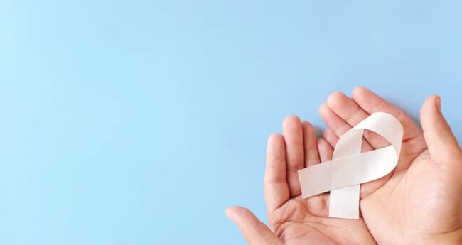 hands holding white ribbon on a light blue background