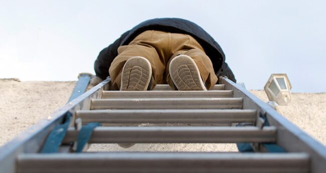 person climbing to the top of a ladder outdoors