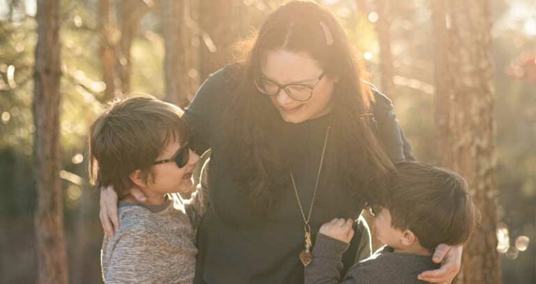 woman hugging two children