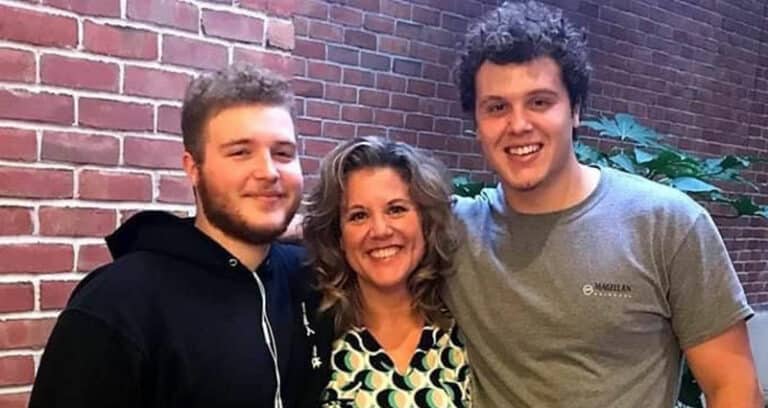woman standing between two young men