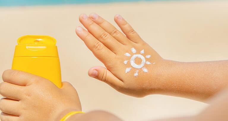 sunscreen drawn in the shape of sun on back of hand