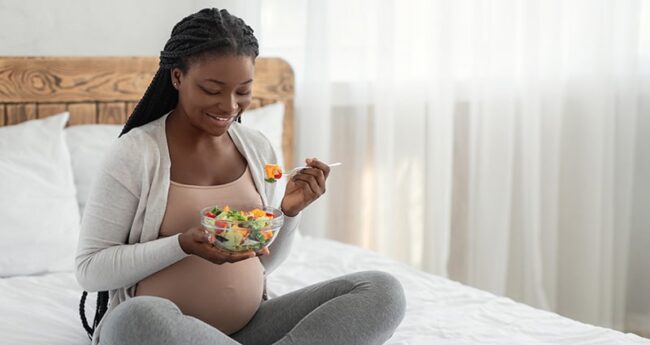 WomensHealth_2022-0324_EatingWellGestationalDiabetes Pregnant woman eating a salad