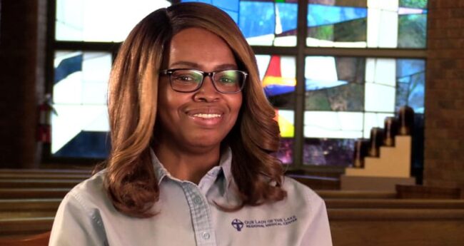 Blog_greeter_web woman smiling in front of stained glass