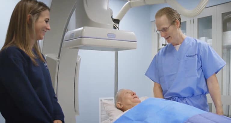 Medical professional speaking with patient lying in bed