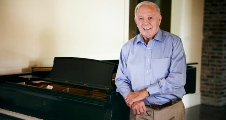 James Devin Moncus standing next to piano