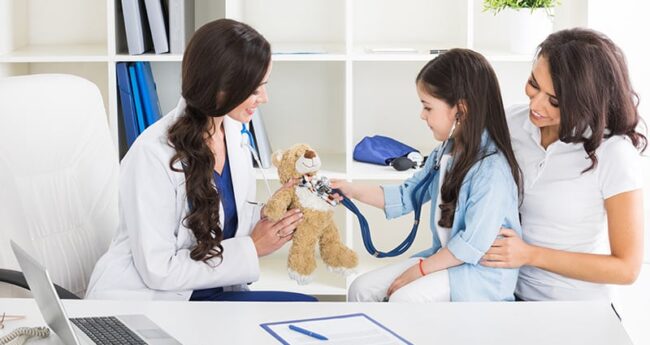 ChildrensHealth_20220806_WhatTypeOfCare child playing with stethoscope and teddy bear during pediatrician visit