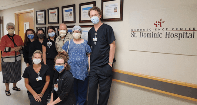 Richard and Sheila Conn (back, in khaki and blue shirts) with St. Dominic Hospital staff.
