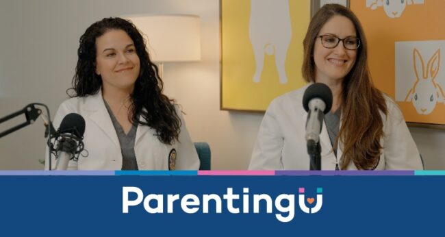 Dr. Lisa Morris and Dr. Laura Hetzler in white lab coats smiling in front of microphones