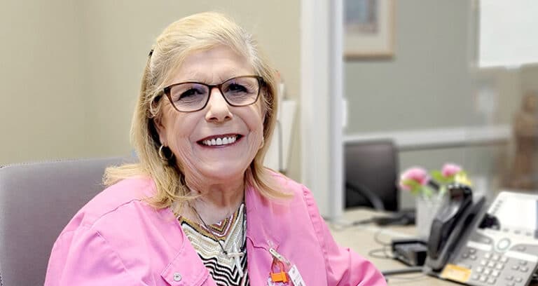 Medical professional sitting at desk and smiling