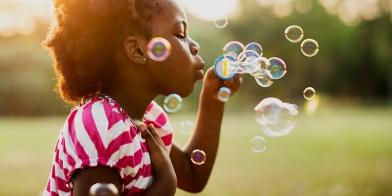 child blowing bubbles
