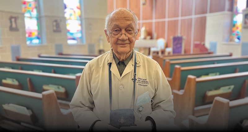 man standing indoors between rows of benches