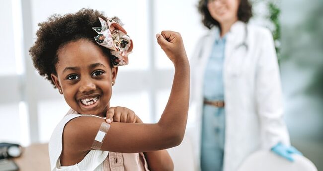 girl showing off her bandaid after vaccination