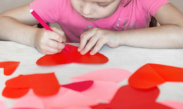 child working on heart arts and crafts project