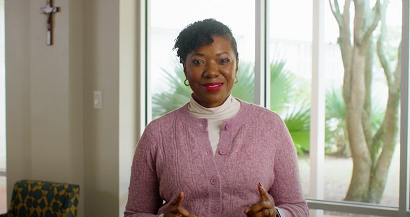 smiling women standing infront of window
