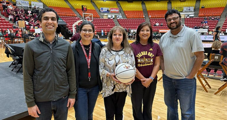 group of adults standing on basketball court
