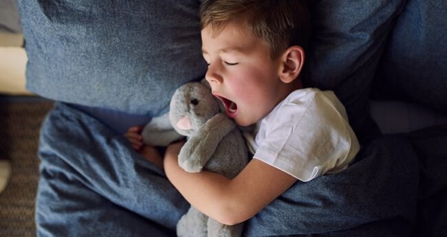ChildrensHealth_2024-0426_SleepMelatoninKids child in bed holding stuffed animal