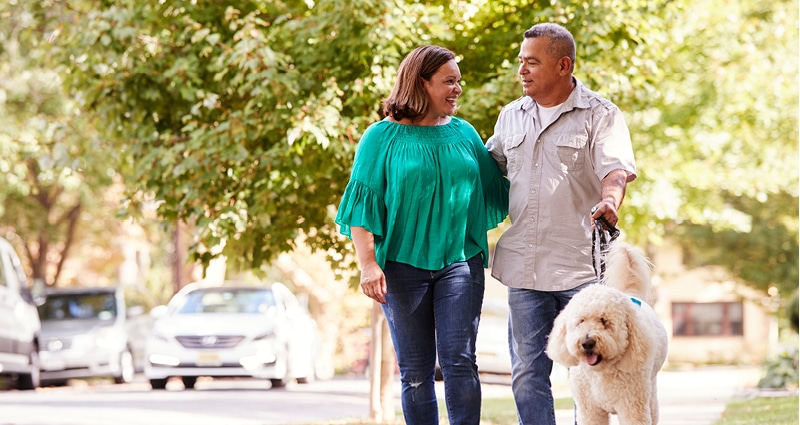 couple walking dog in neighborhood