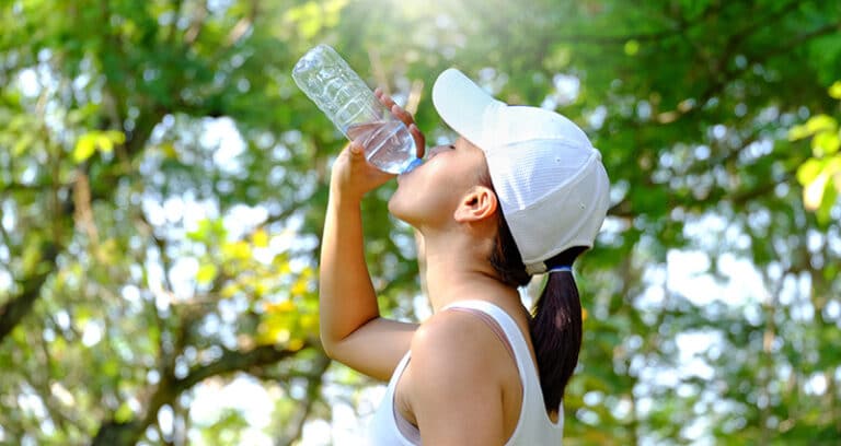 woman drinking water outside