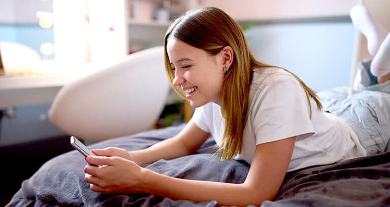 smiling teen using a phone