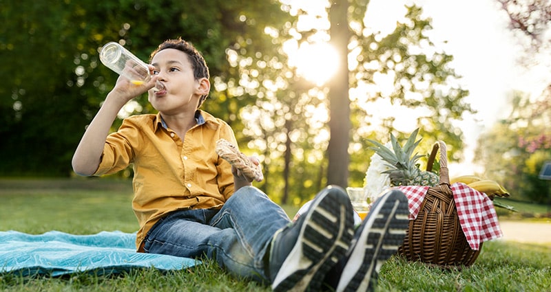 Boy drinking water outside