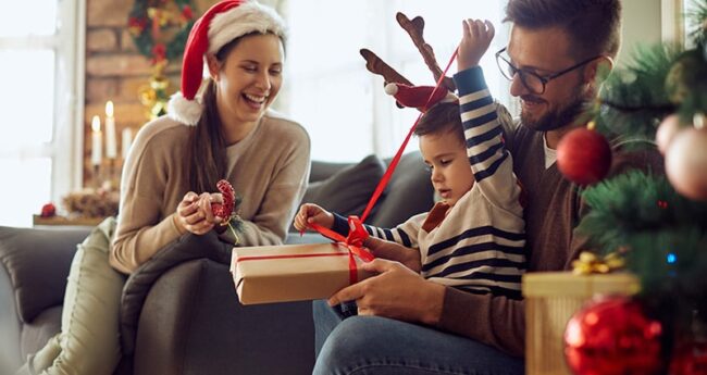 Family of three opening Christmas presents