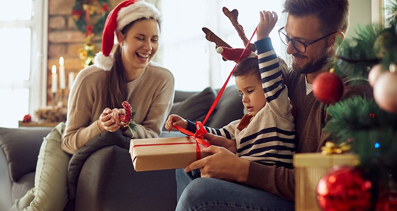 Family of three opening Christmas presents