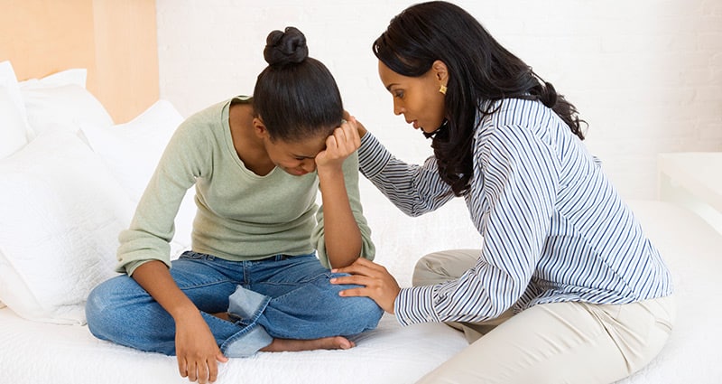 mom comforting her teen daughter