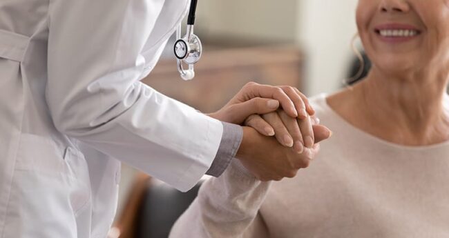 PatientStories_20230321_TreatingPersonNotIllness provider holding patient's hand