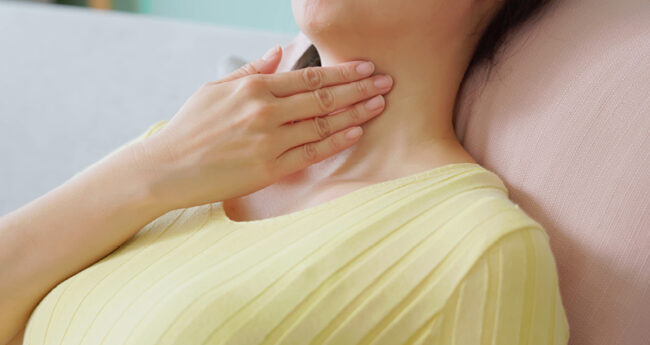 Woman holding her throat