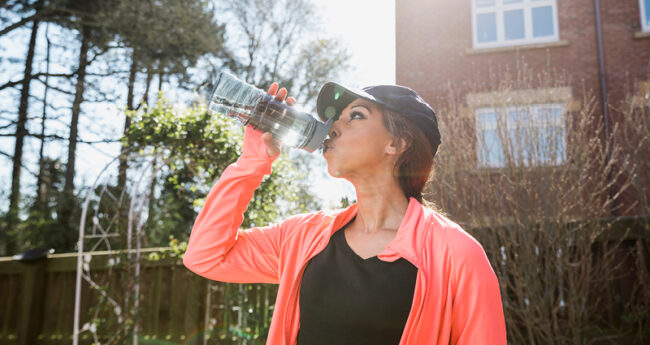 Woman drinking water outdoors