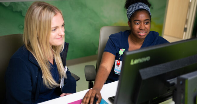 two medical residents work on a computer